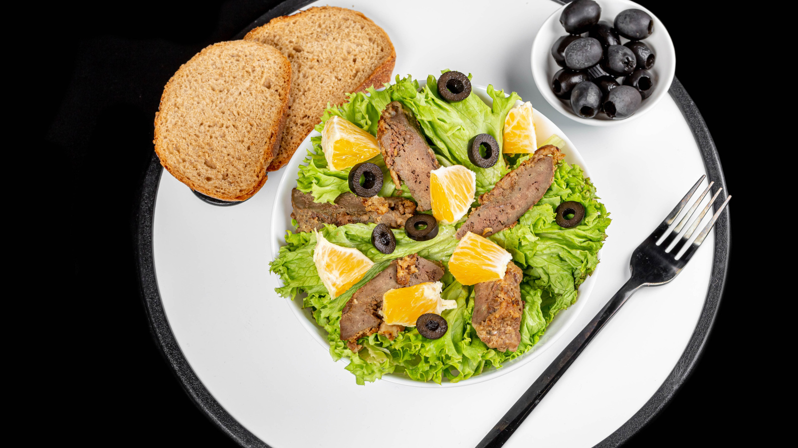 Листья салата с мясом на столе с хлебом