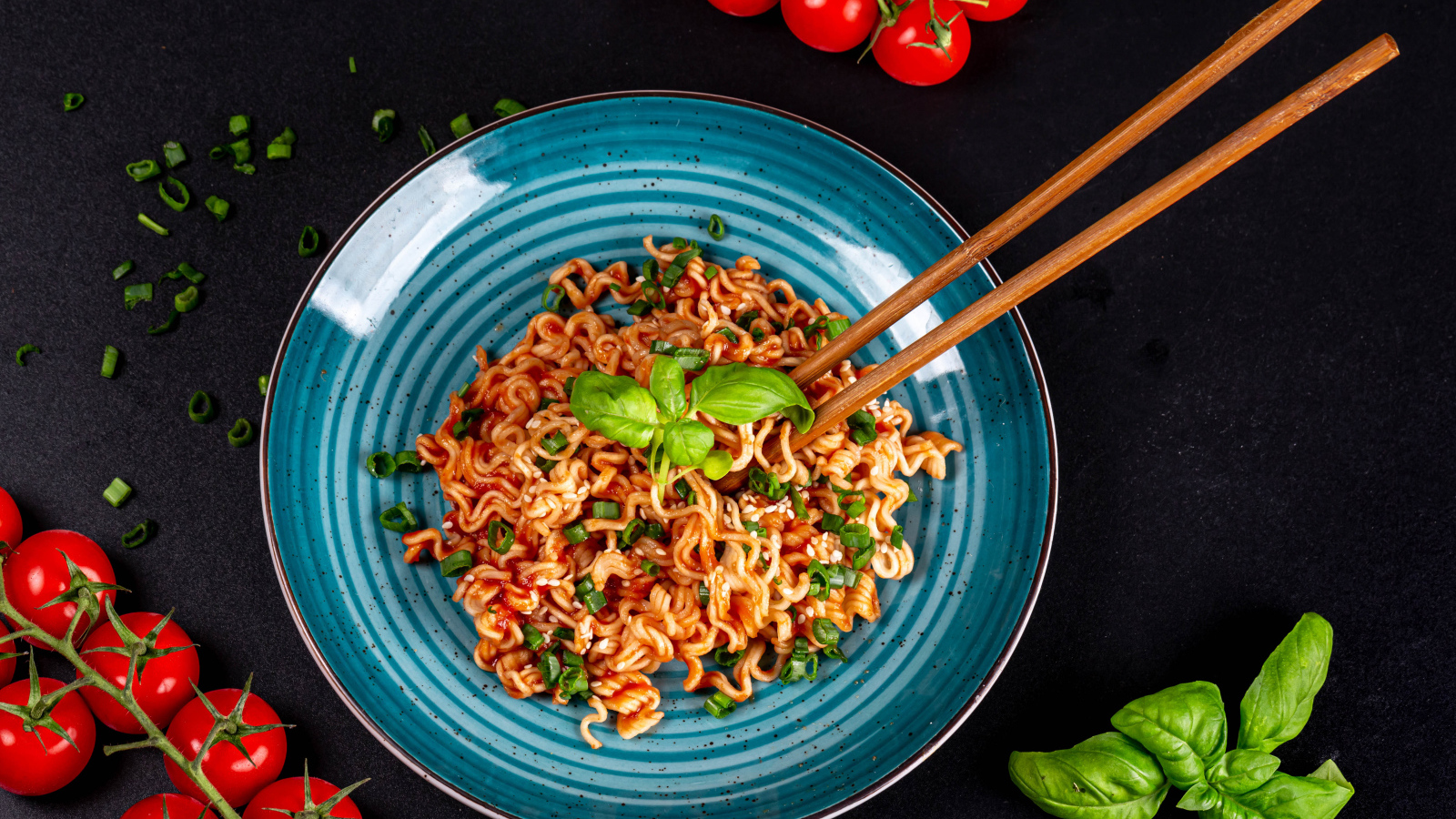 Макароны в соусе на столе с помидорами