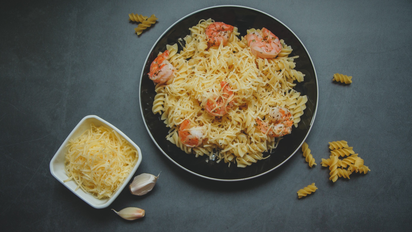 Макароны на тарелке с сыром и креветками