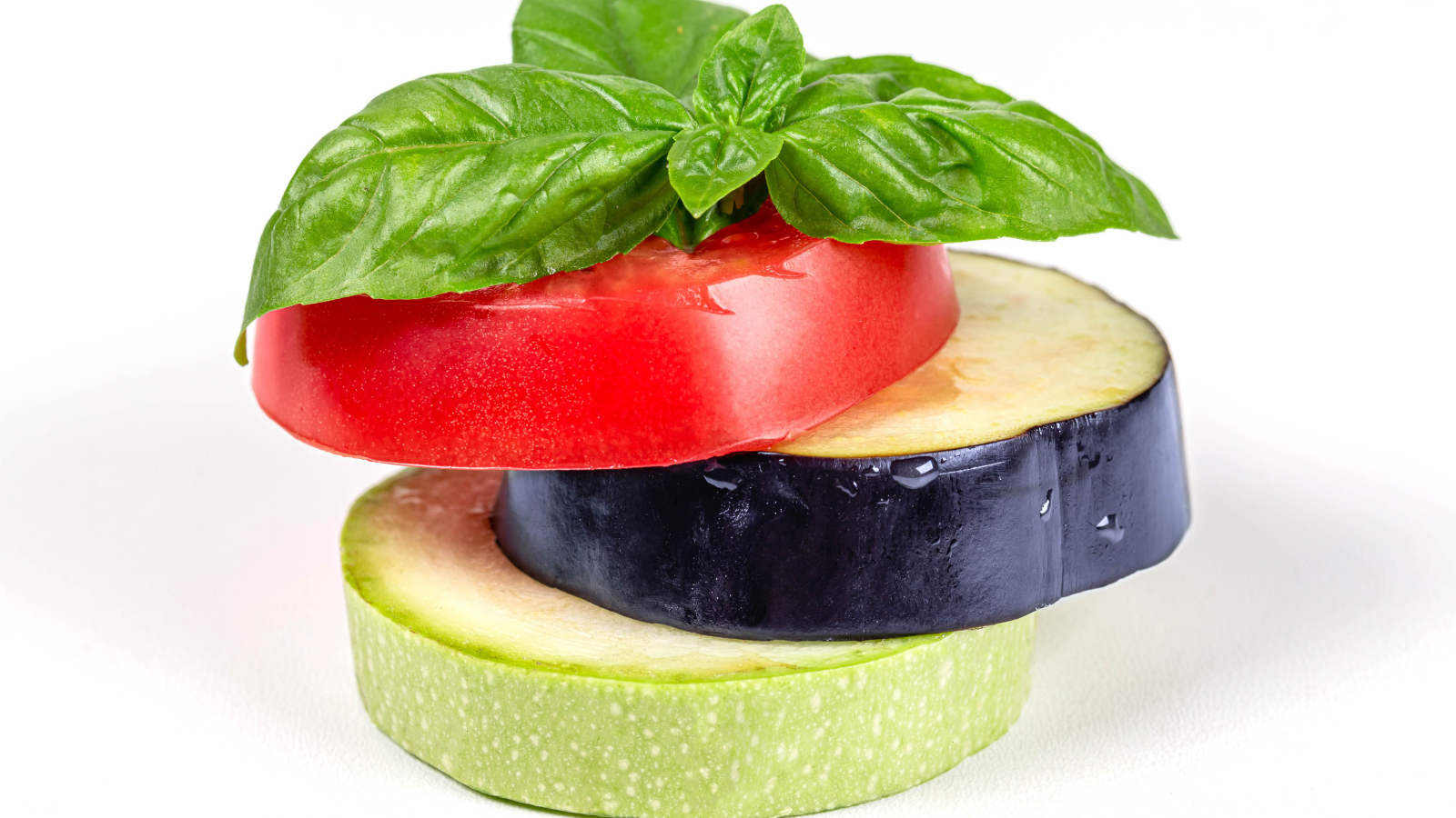 Кусок помидора, баклажана и кабачка на белом фоне