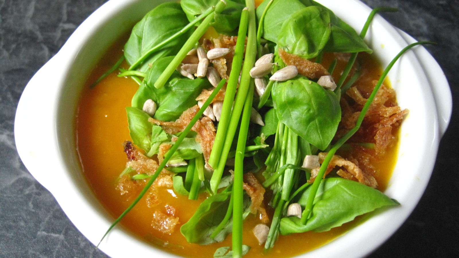 Тыквенный суп с зеленью в белой тарелке