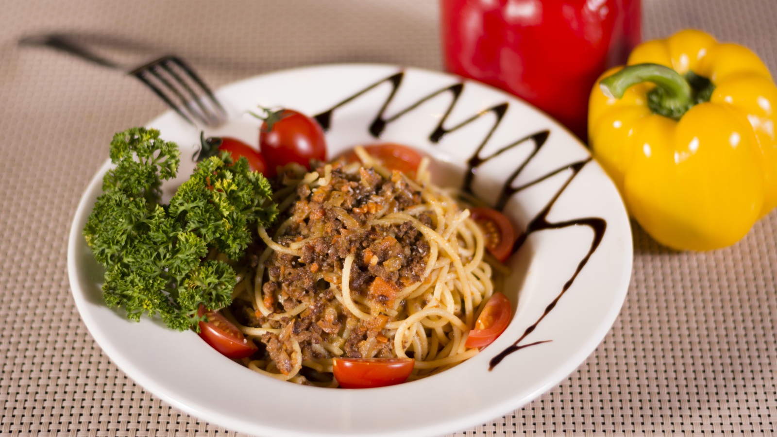 Спагетти с фаршем и помидорами в тарелке 