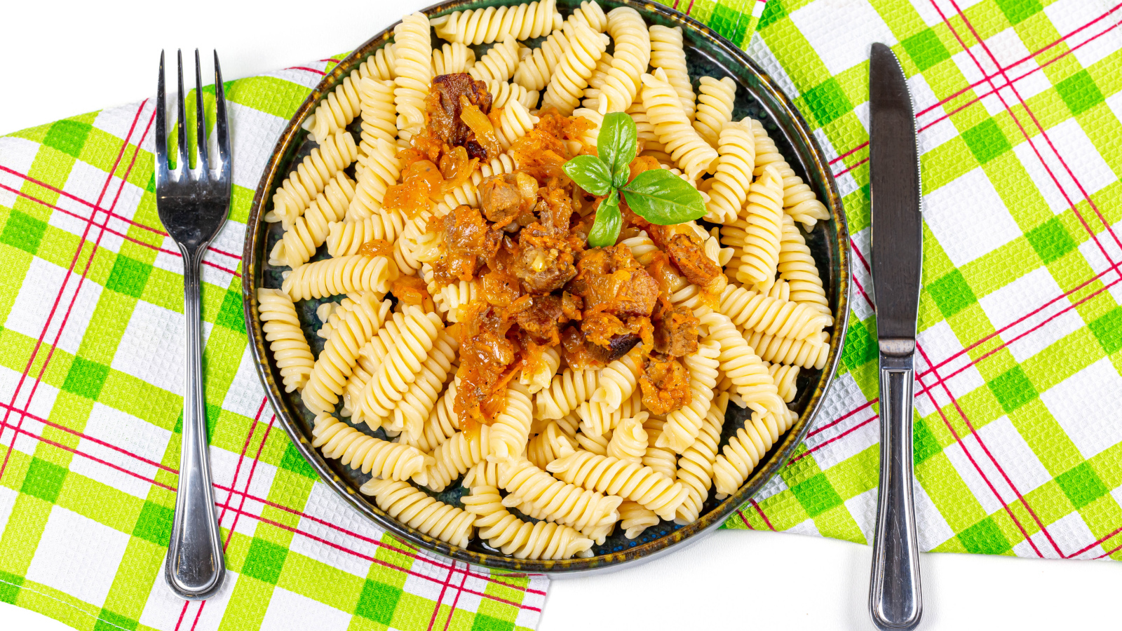 Макароны спираль с мясом на тарелке