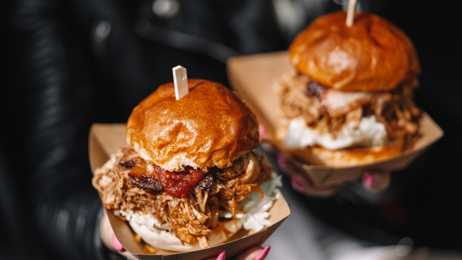 Два гамбургера в коробках в руках у девушки