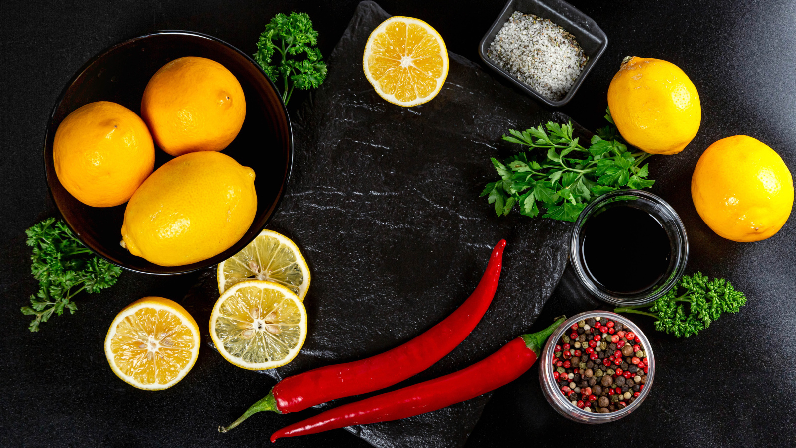 Лимоны на столе с красным перцем, петрушкой  и специями