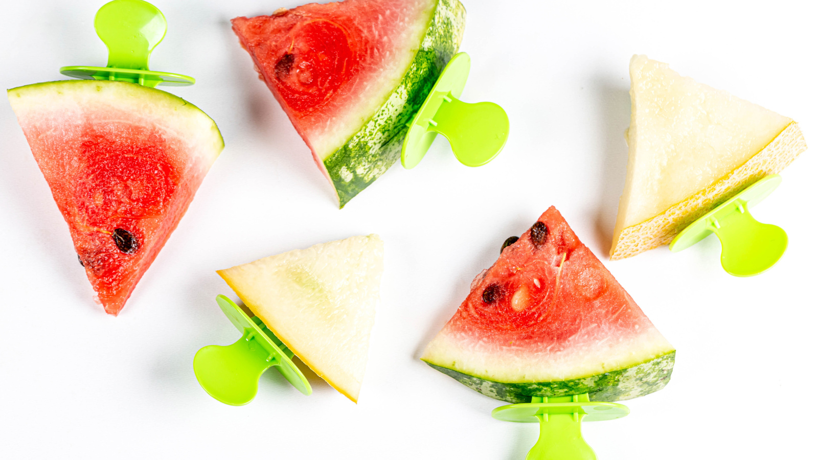 Кусочки арбуза и дыни на палочке на белом фоне 