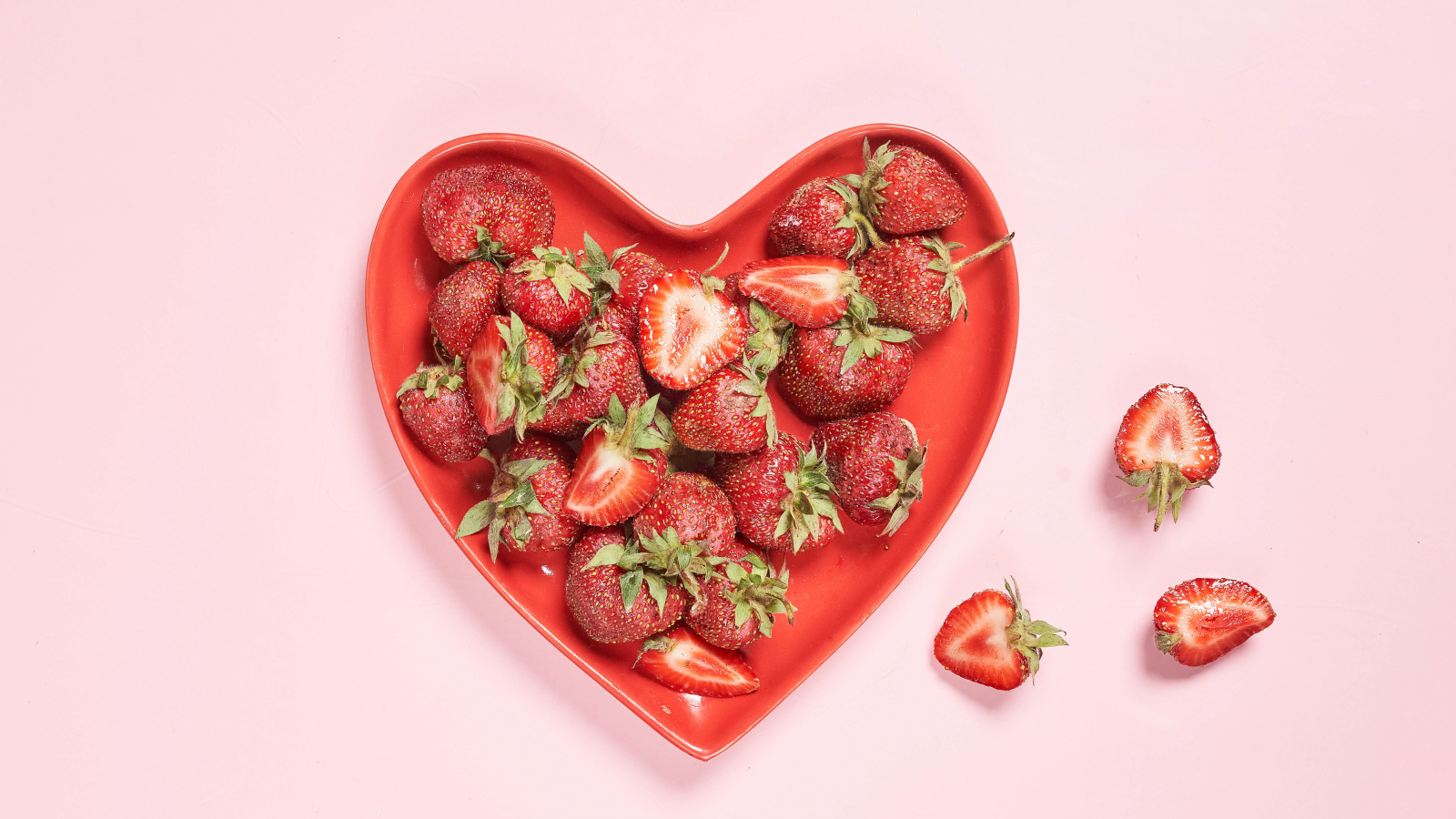 Красная тарелка в форме сердца с клубникой 