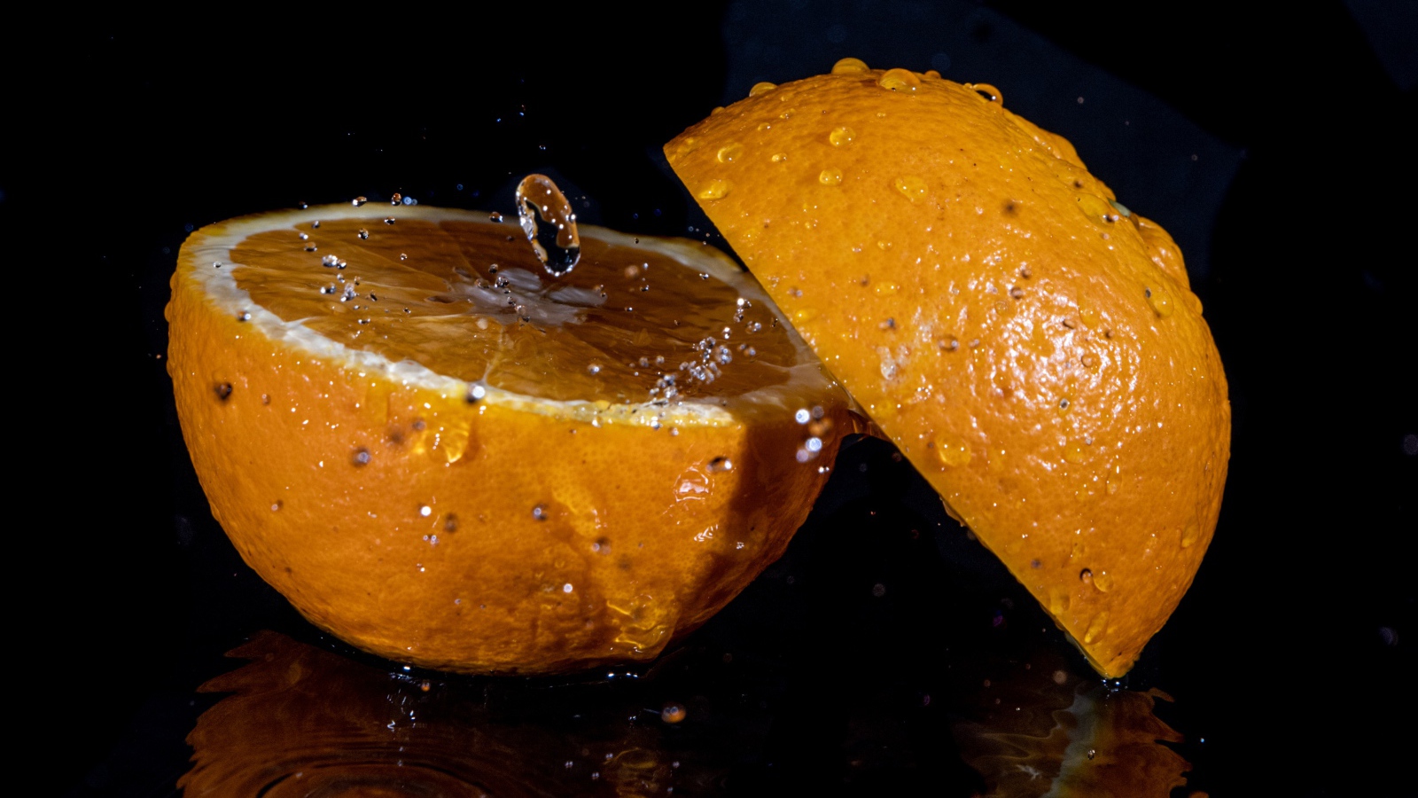 Две половины апельсина на черном фоне 