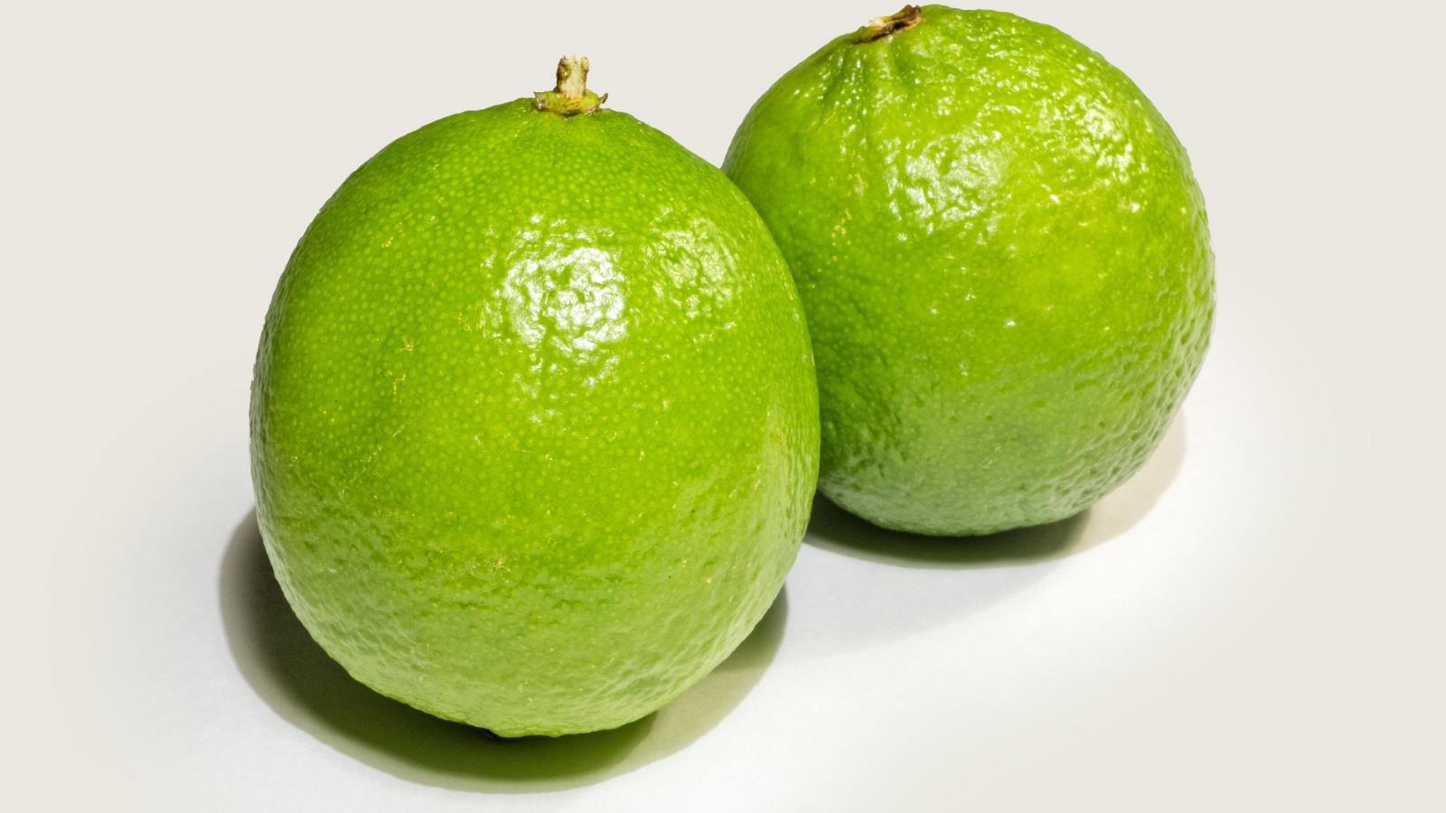 Два больших зеленых лайма на столе