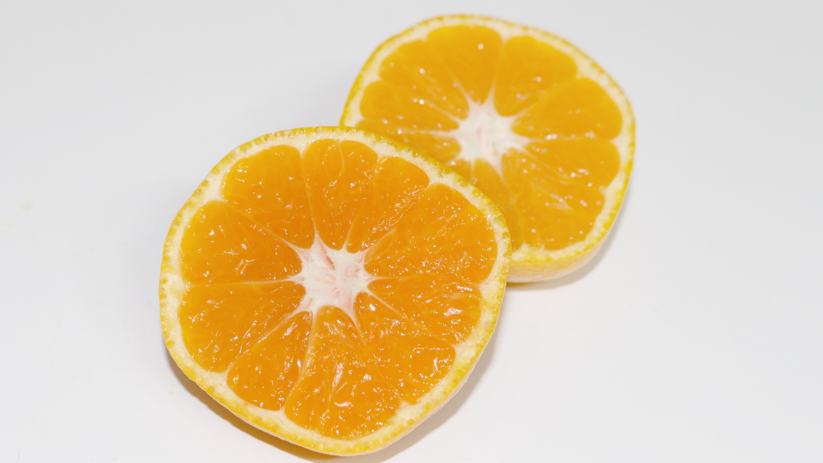 Два кружочка мандарина на сером столе 