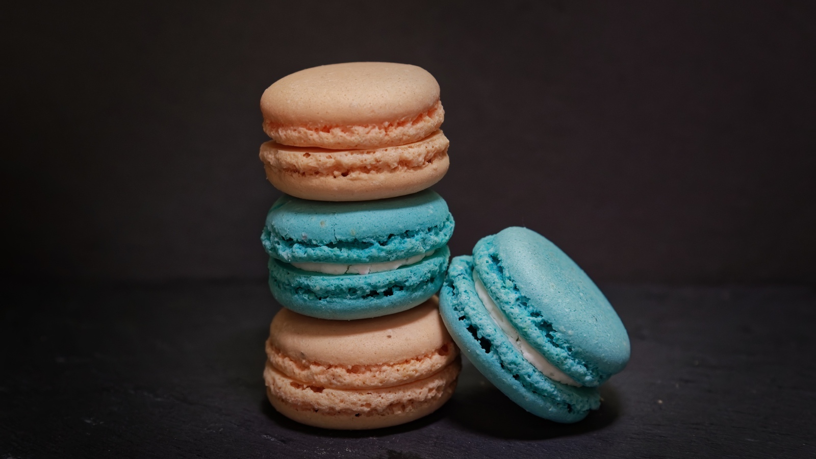 Голубой и коричневый десерт макарун на сером фоне