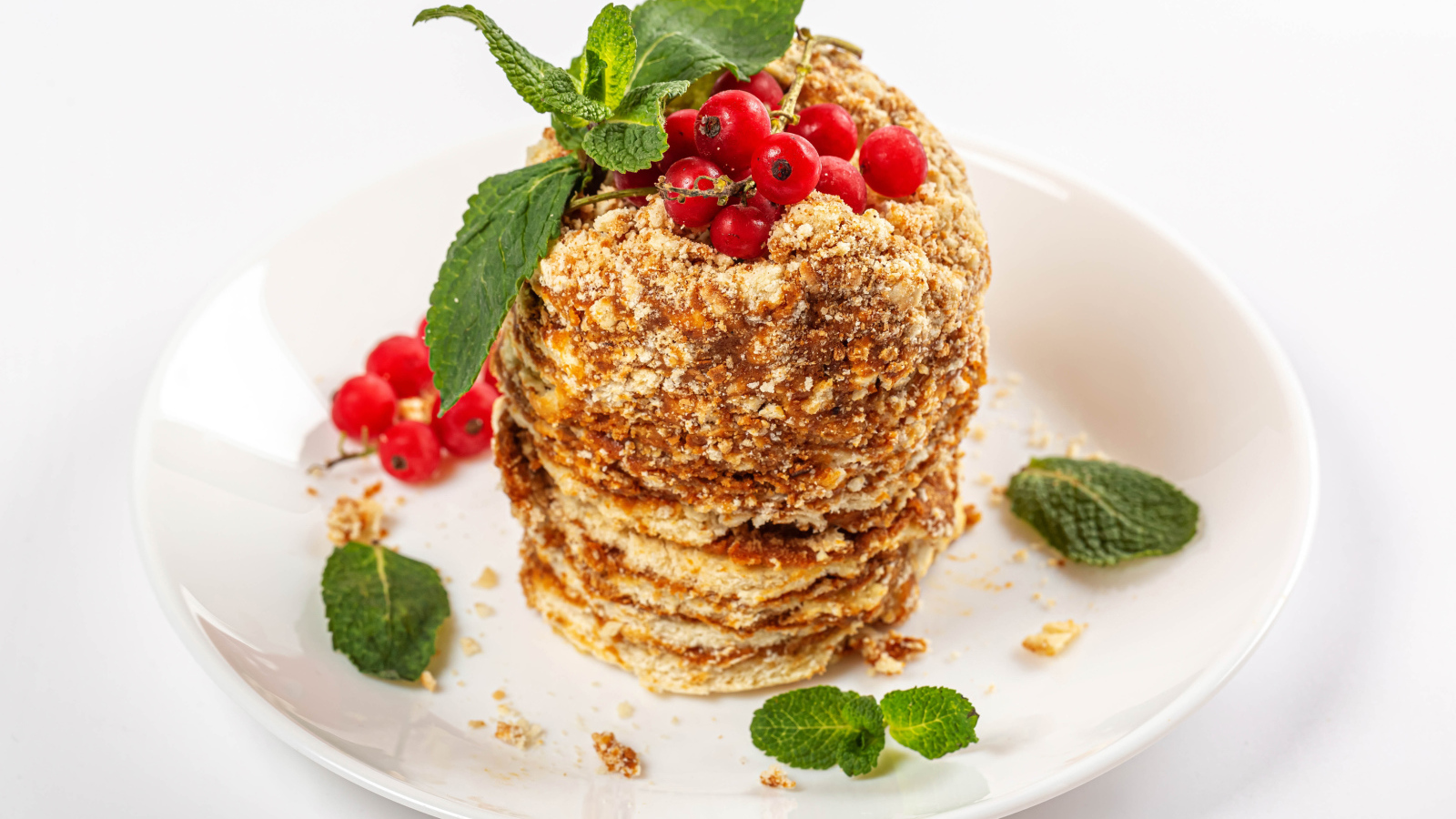 Вкусное пирожное со сгущенкой и ягодами красной смородины на белом фоне