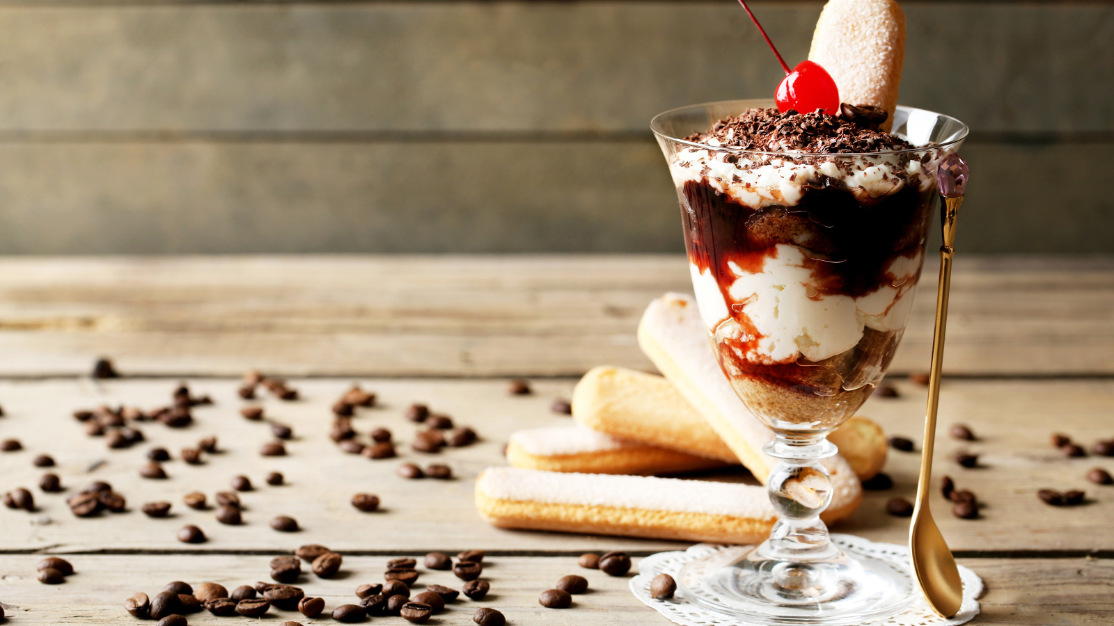 Десерт с печеньем савоярди на столе с кофейными зернами