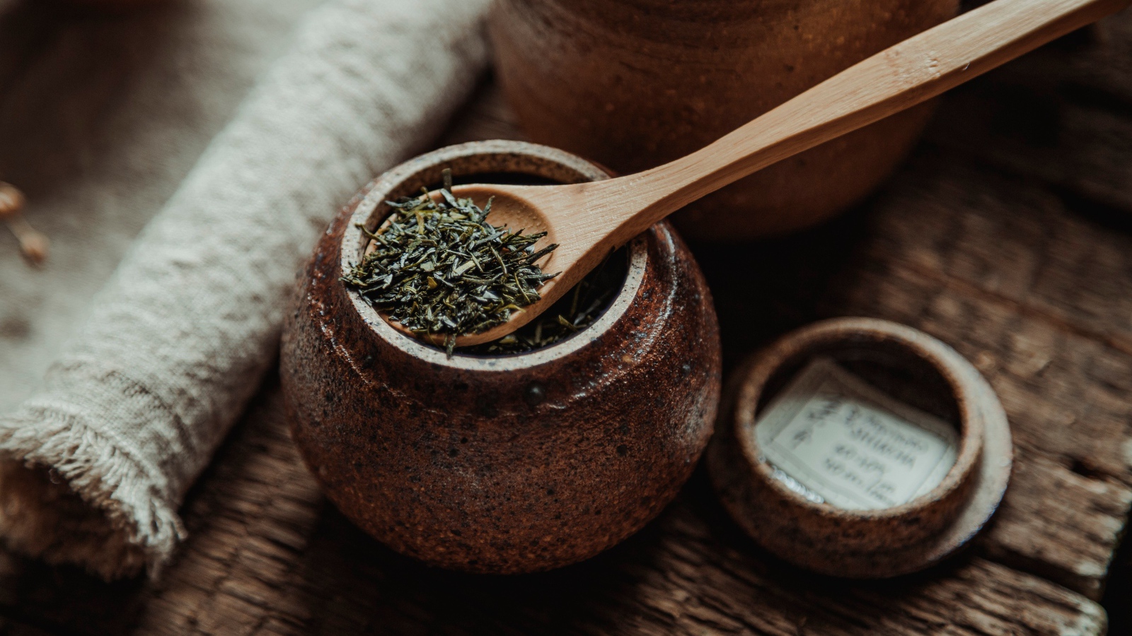 Глиняный горшочек с листовым чаем и деревянной ложкой 