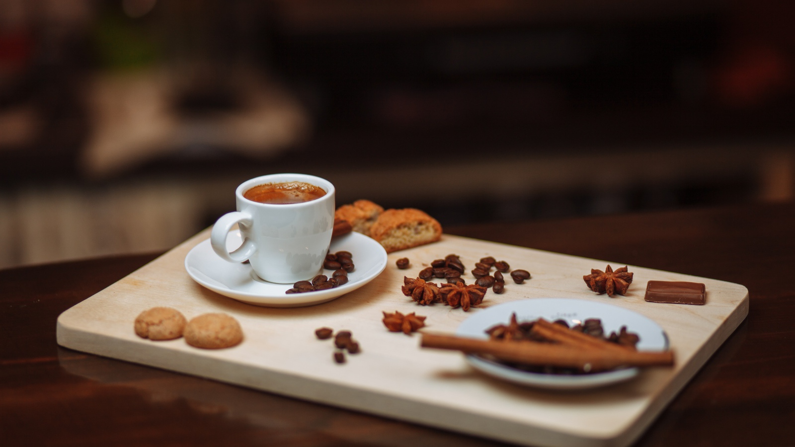 Маленькая чашка кофе на столе с корицей, бадьяном и печеньем 
