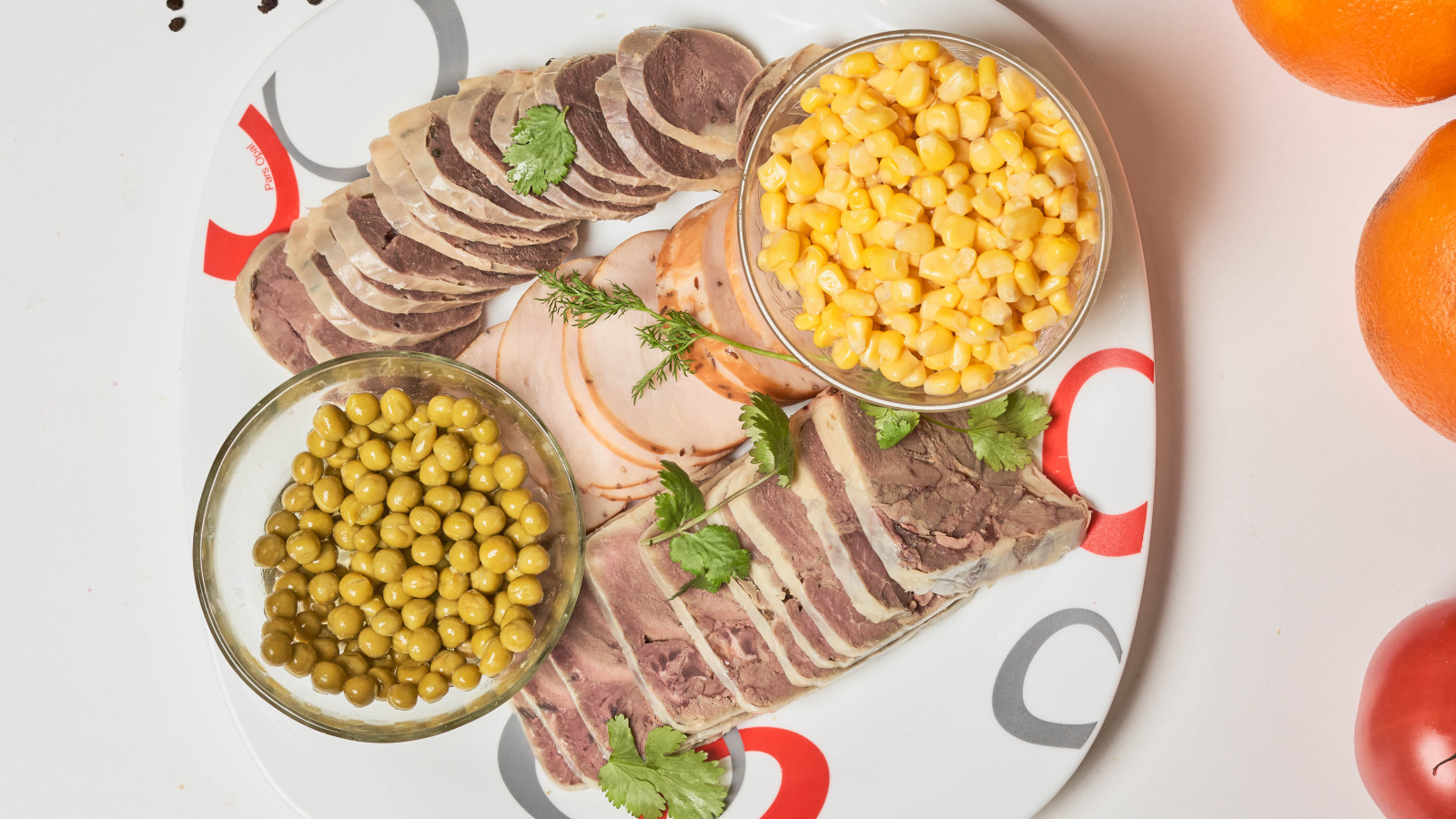 Мясные продукты на тарелке с кукурузой и зеленым горошком 