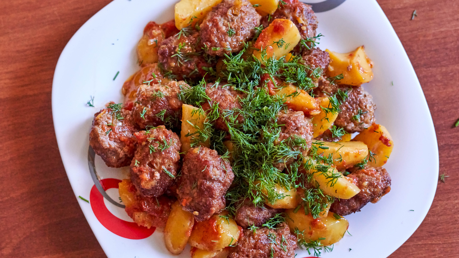 Фрикадельки с картофелем и укропом на белой тарелке