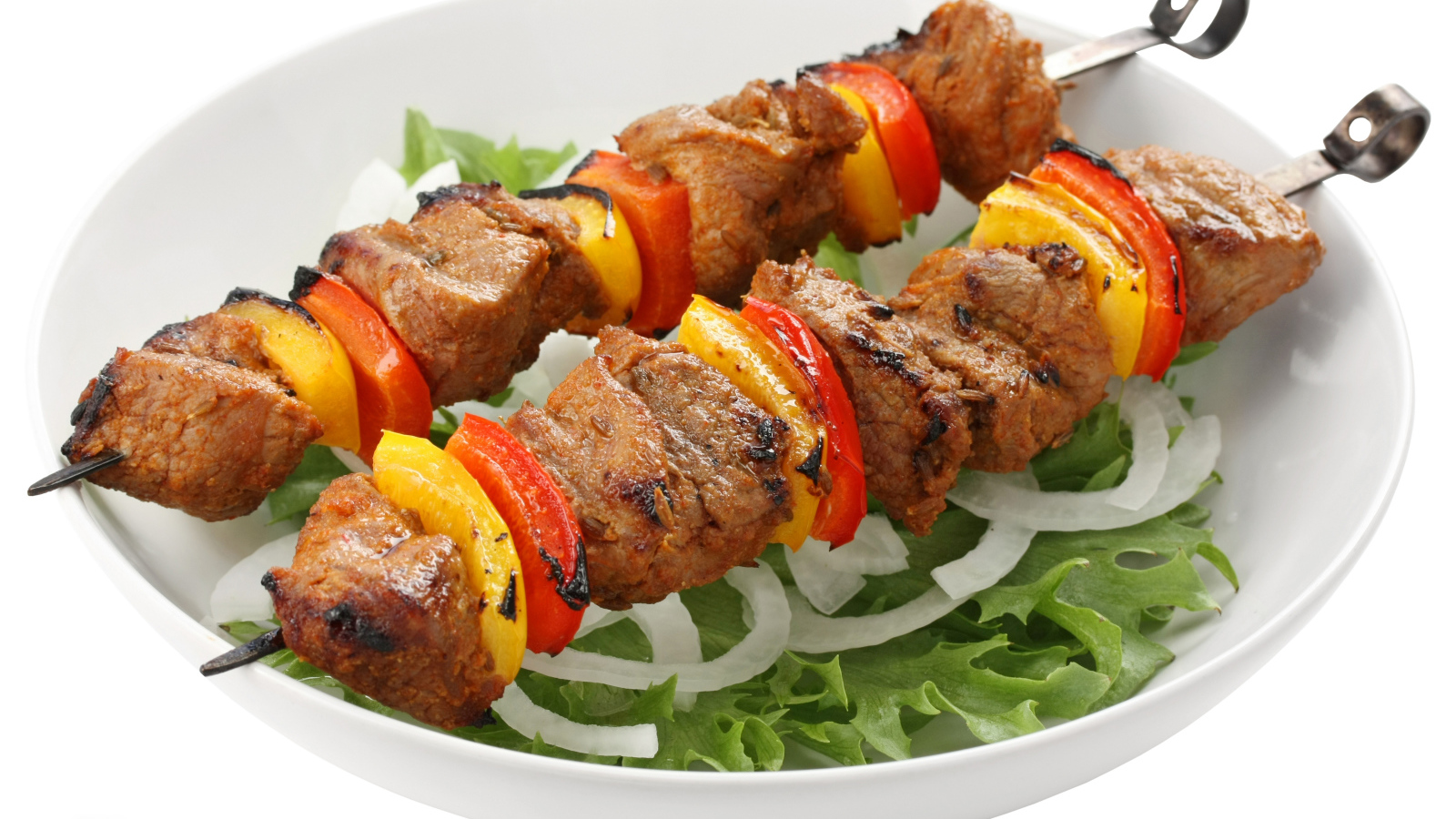 Шашлык с болгарским перцем на тарелке с листьями салата