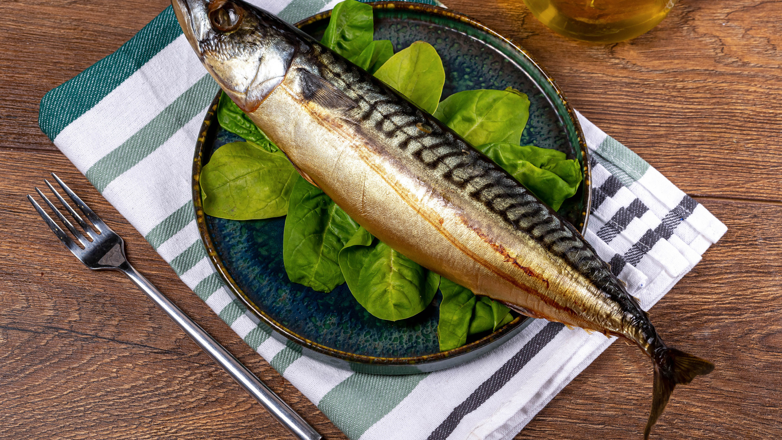 Large fat mackerel on a plate of basil