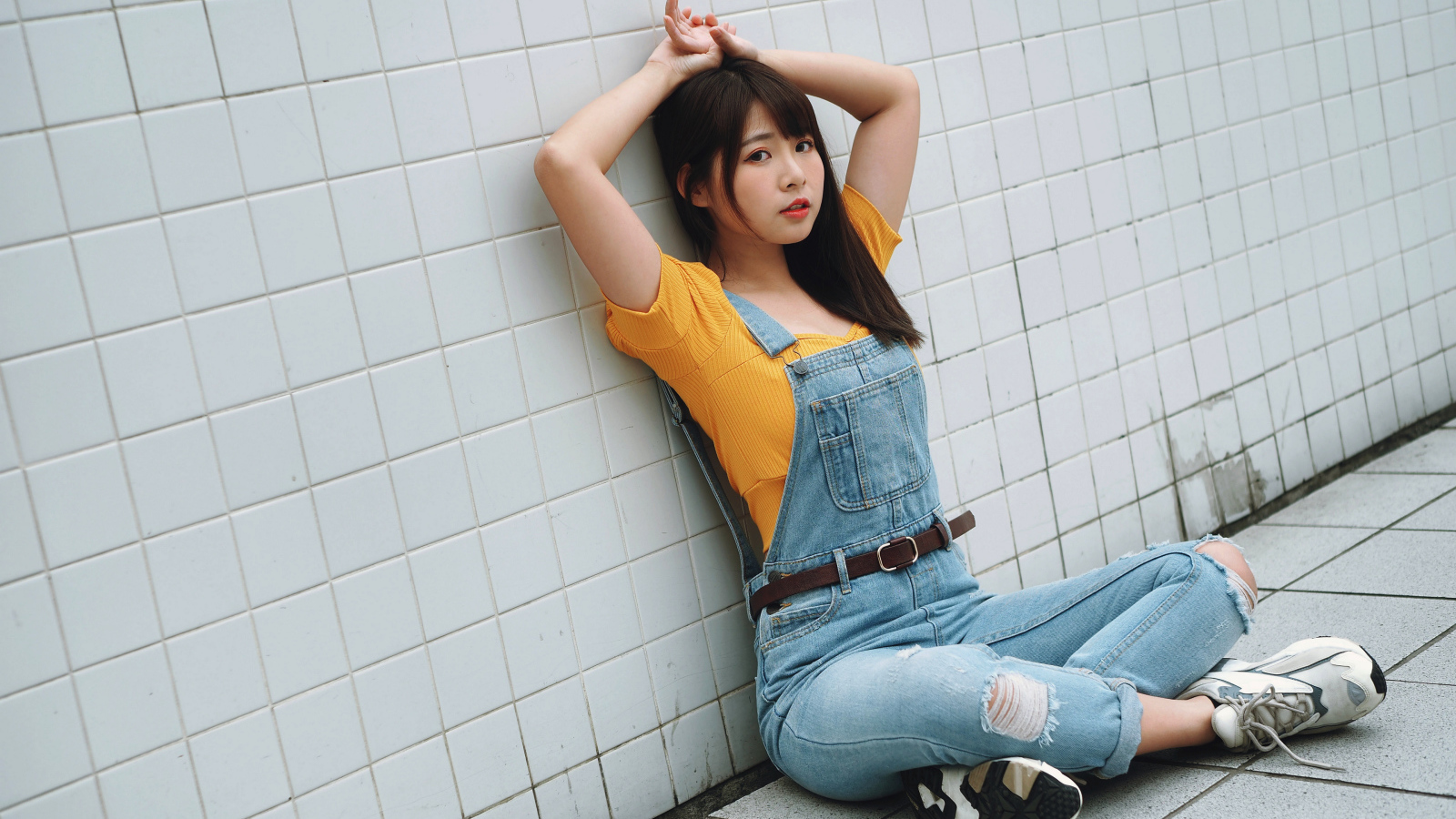 Девушка азиатка в джинсовом комбинезоне 