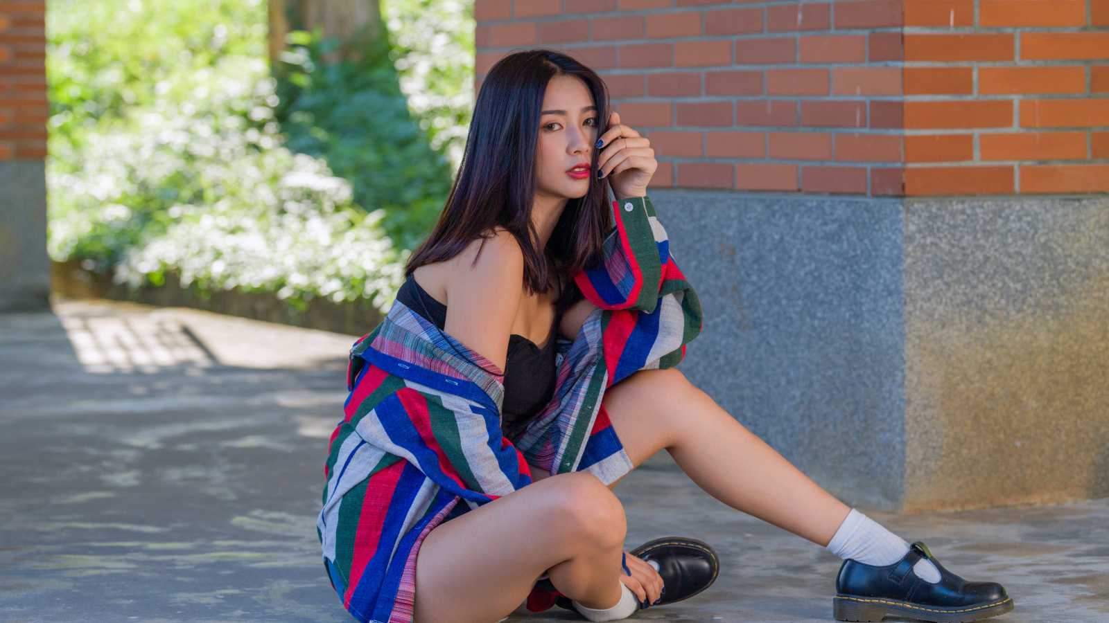 Красивая азиатка в рубашке у стены