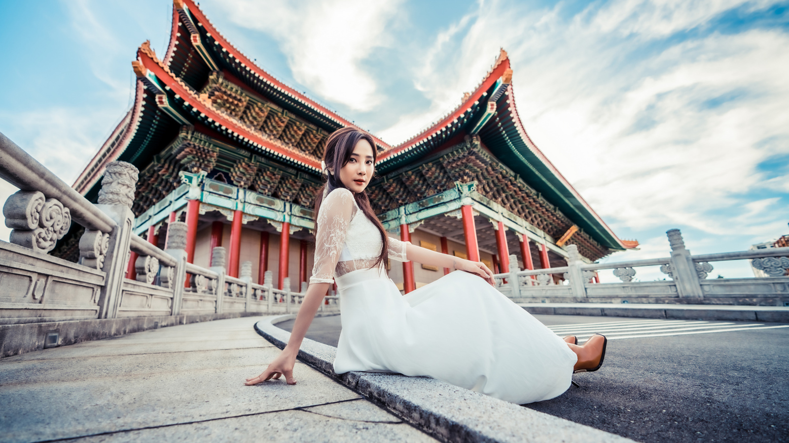 Красивая азиатка в белом платье на фоне храма