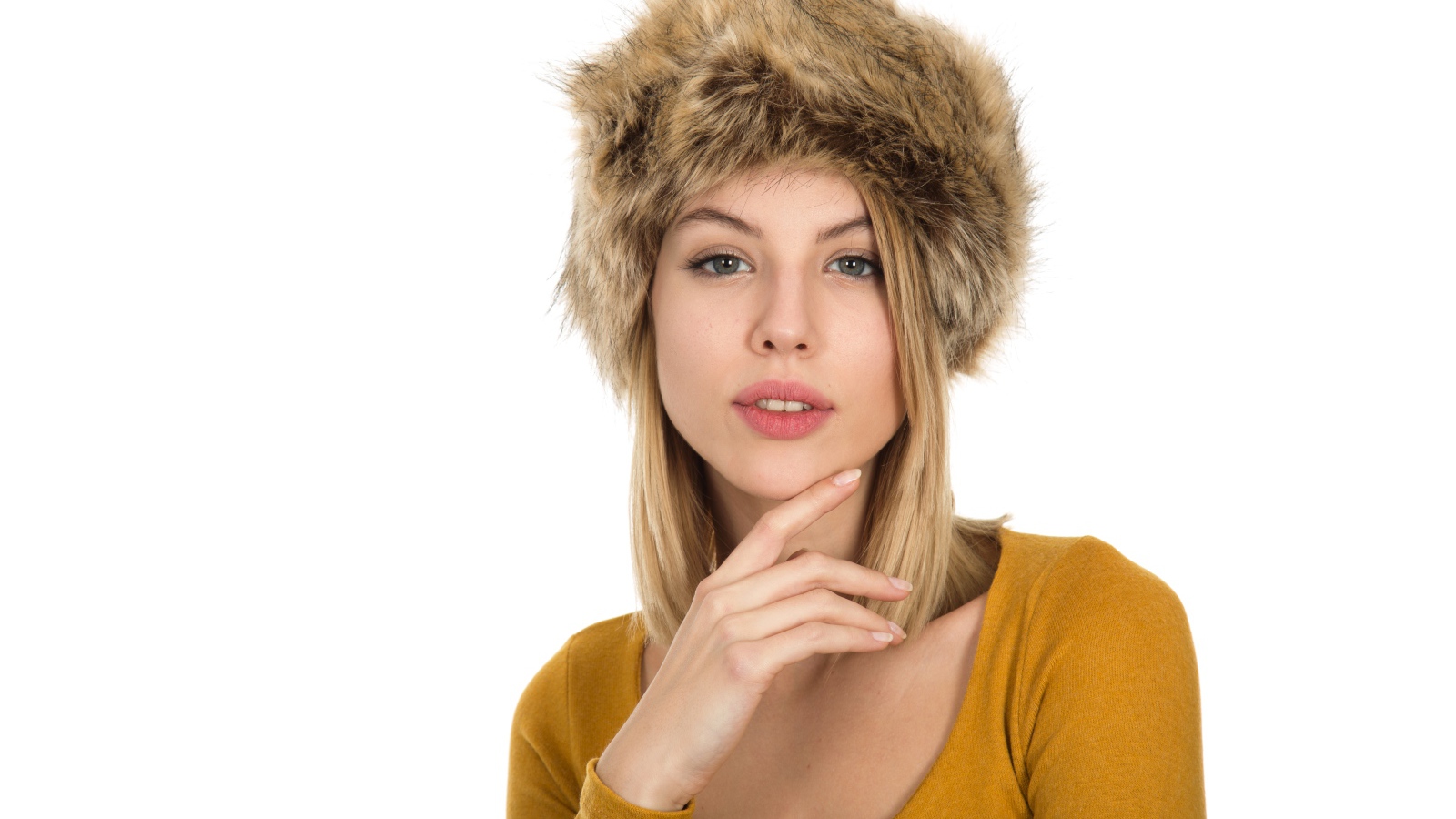 Красивая девушка блондинка в меховой шапке на белом фоне 