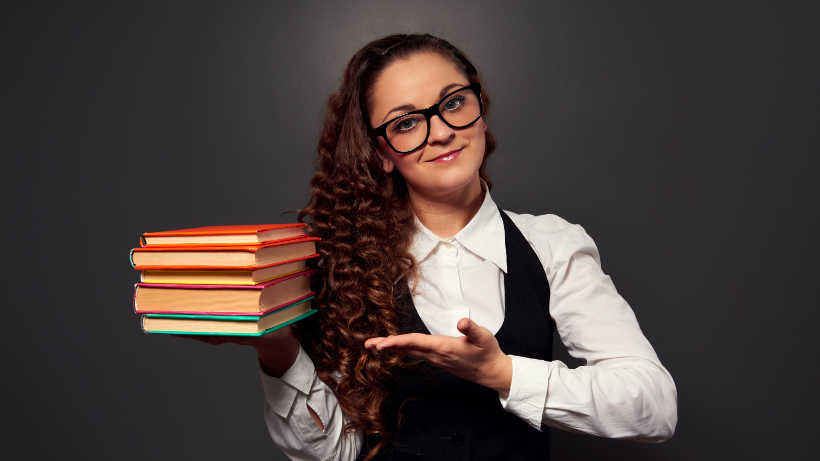 Красивая девушка учитель в очках с книгами в руке