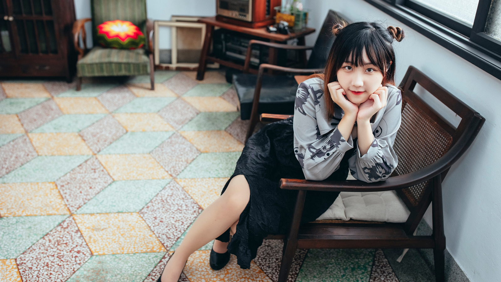 Красивая молодая азиатка сидит в кресле