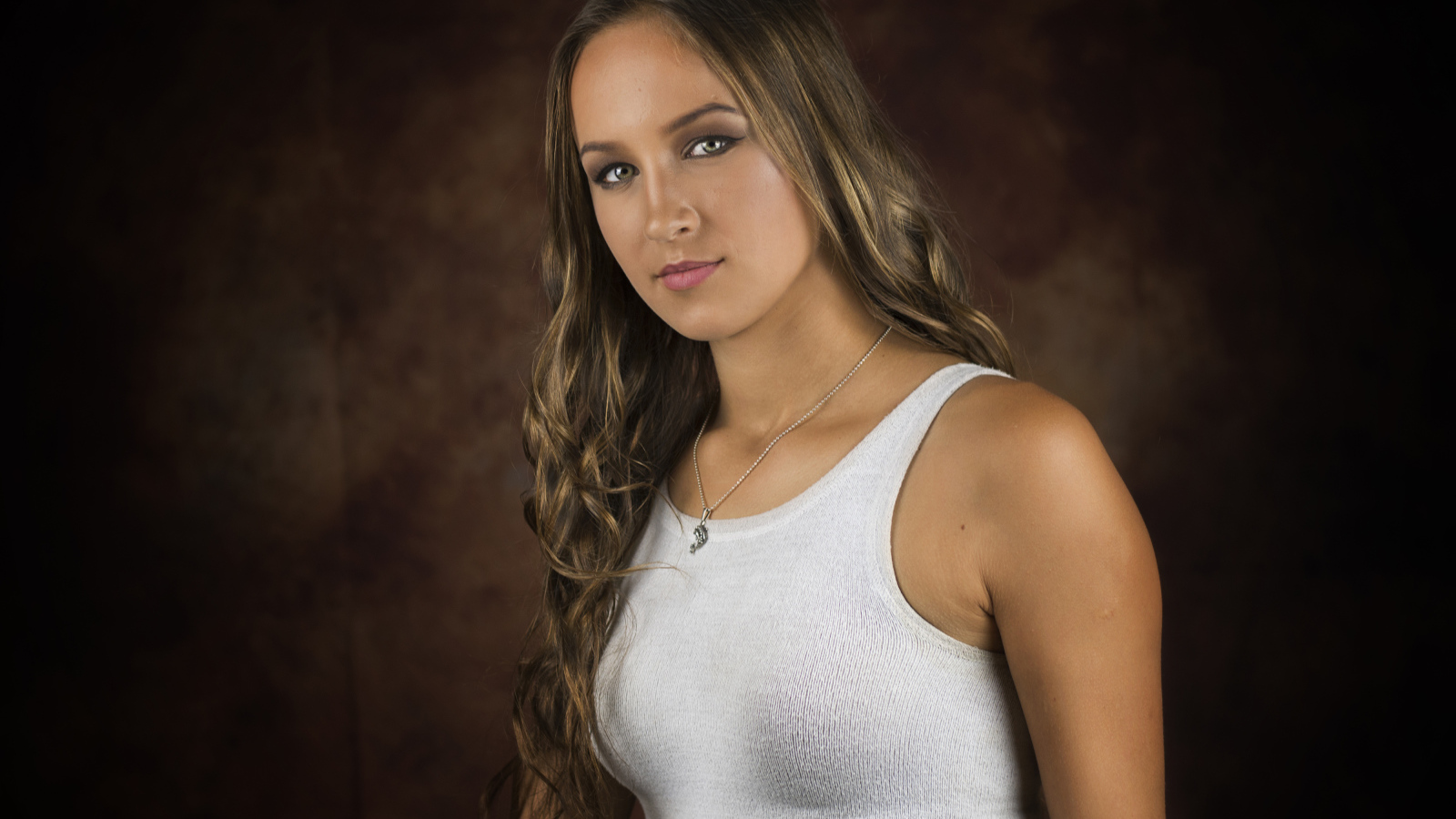 Красивая молодая девушка с длинными волосами в белой майке 