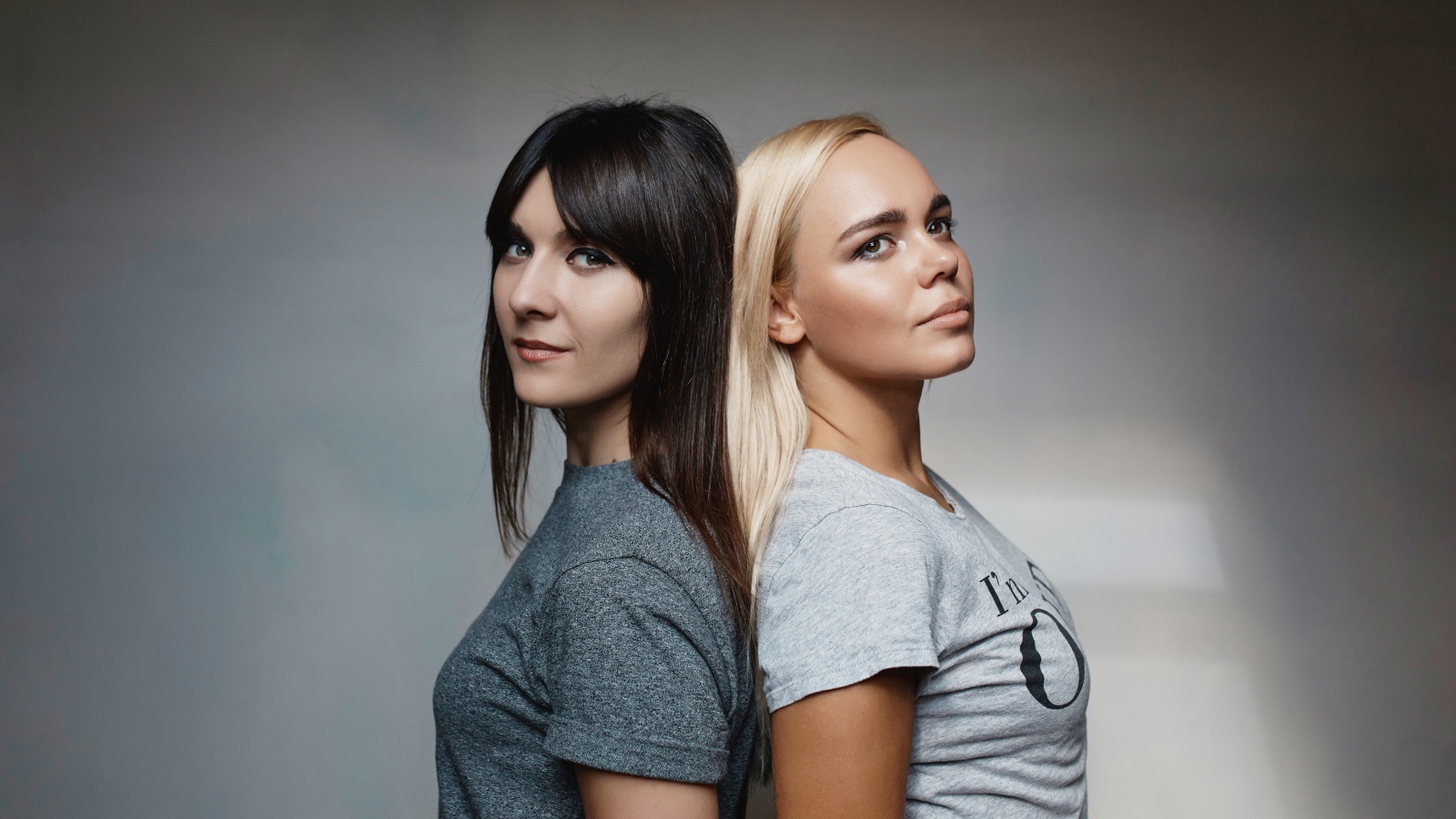 Блондинка и брюнетка на сером фоне