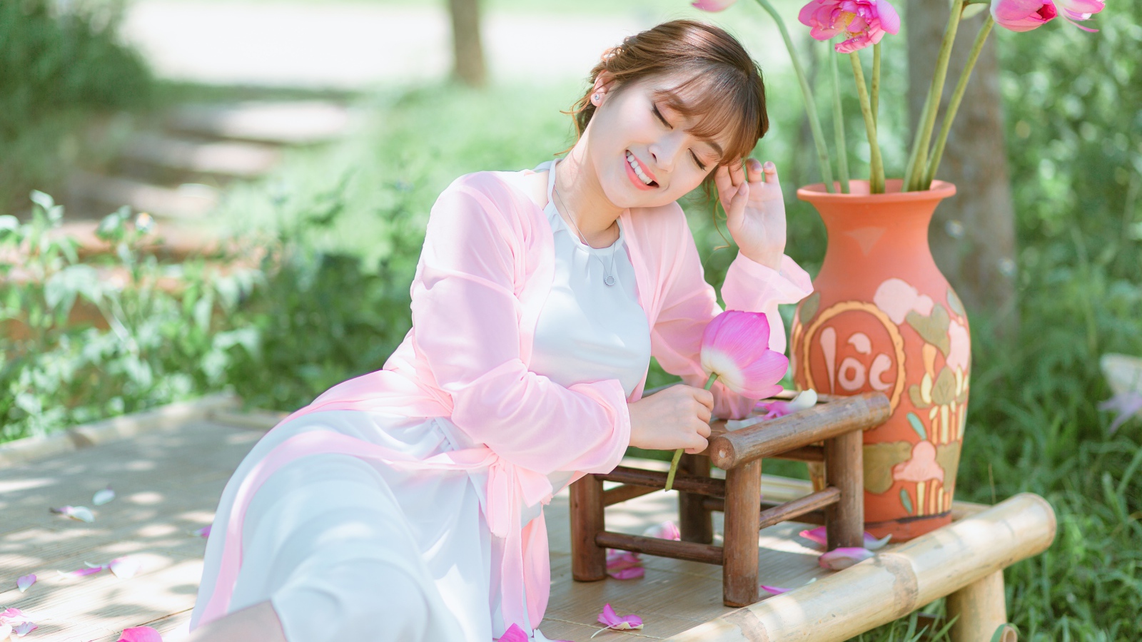 Мечтательная девушка азиатка с цветами лотоса