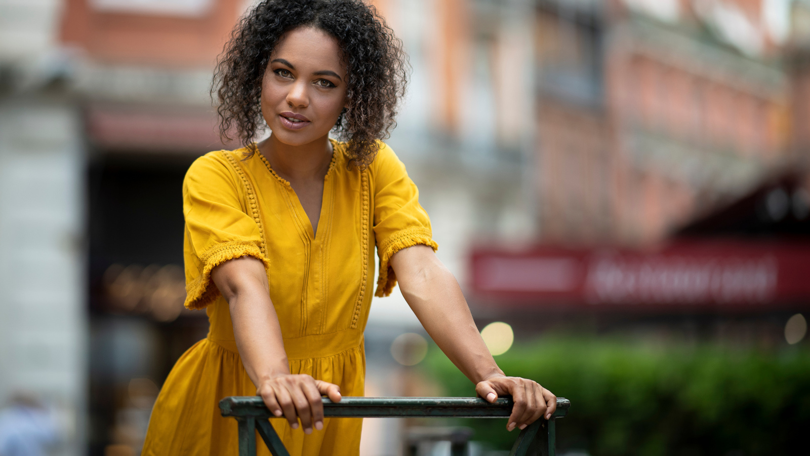 Девушка с кудрявым волосами в желтом платье