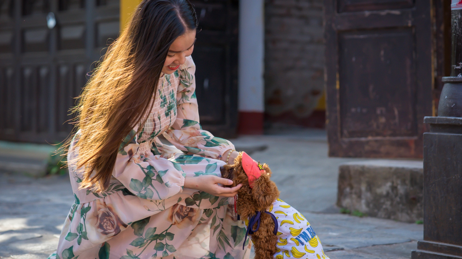 Улыбающаяся девушка азиатка с собакой 