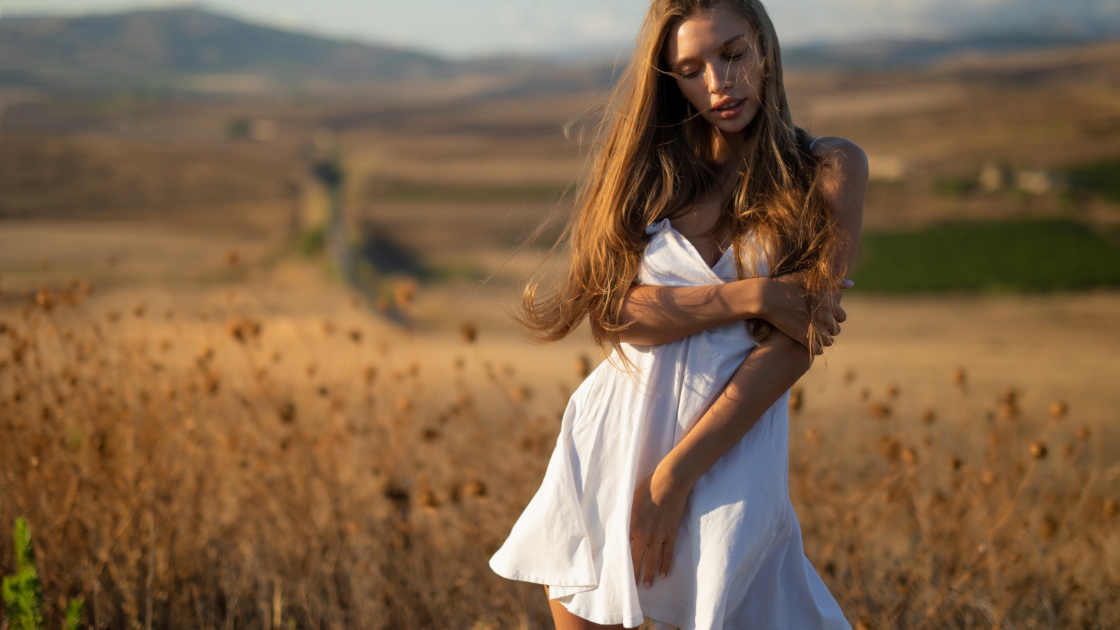 Нежная девушка в белом платье в лучах солнца 