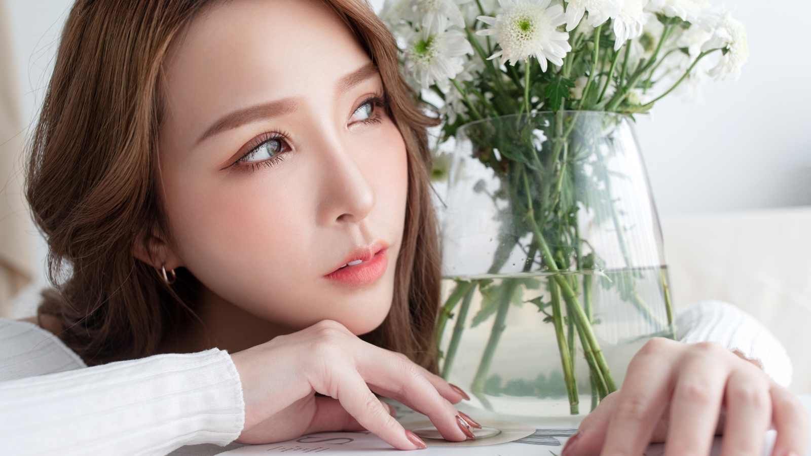 Молодая азиатка с букетом белой хризантемы в вазе