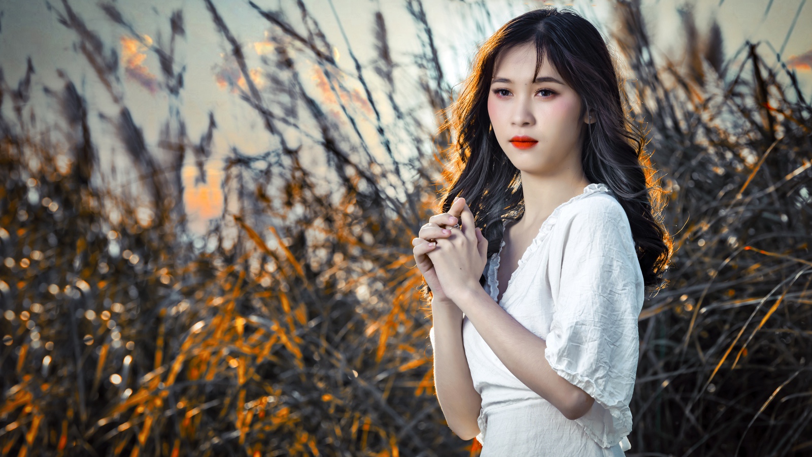 Молодая девушка азиатка в белом платье на закате