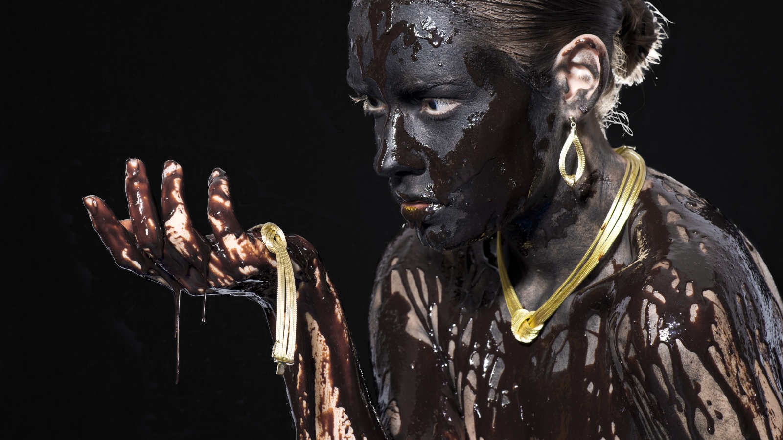 Молодая девушка в грязи на черном фоне