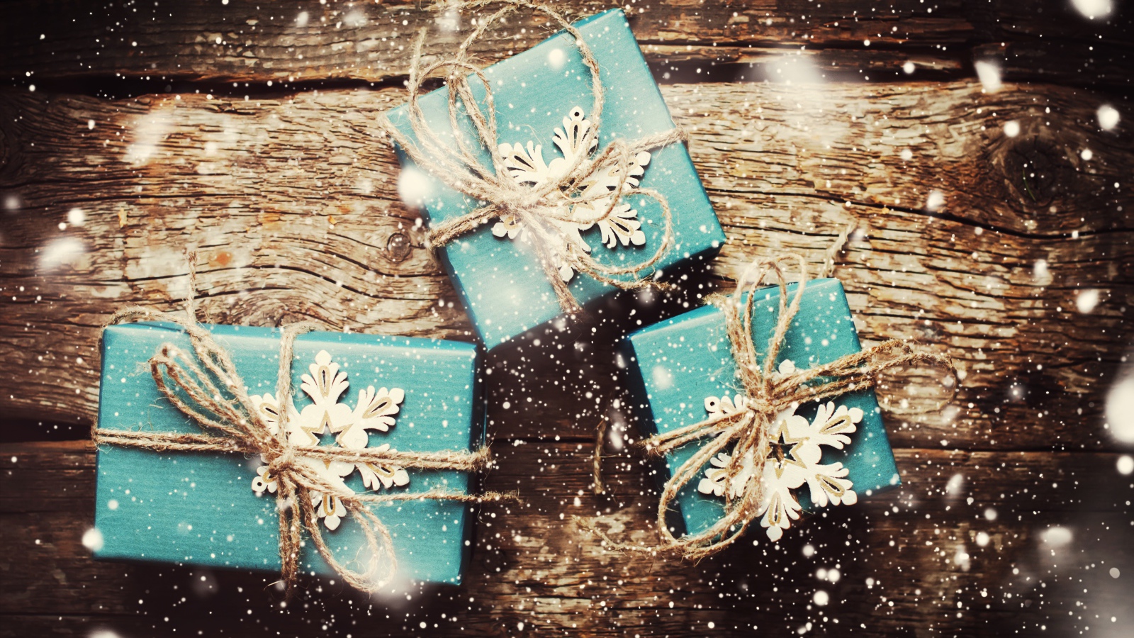 Three blue gifts on a wooden table