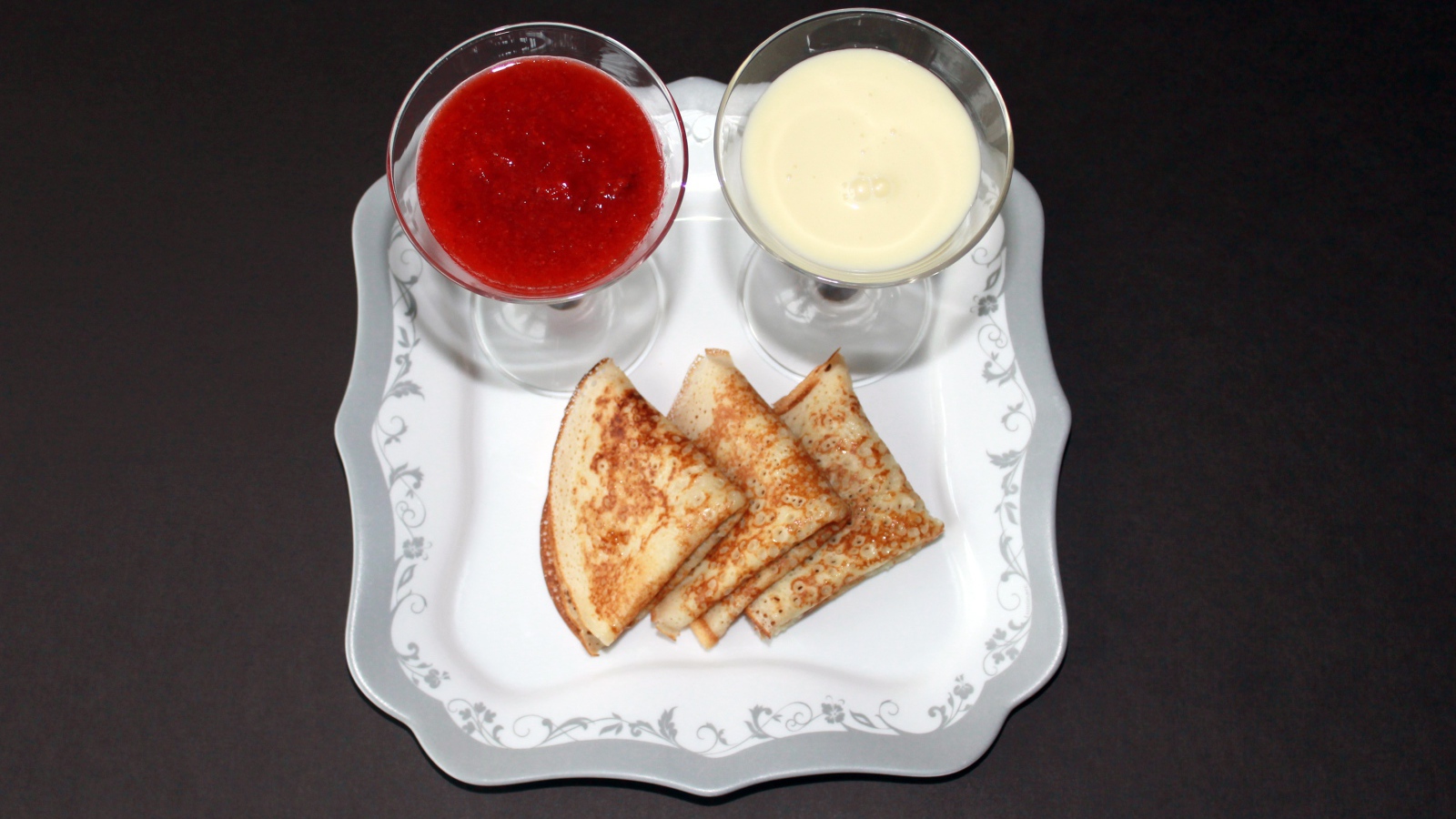 Блинчики с вареньем и сметаной на столе на Масленицу