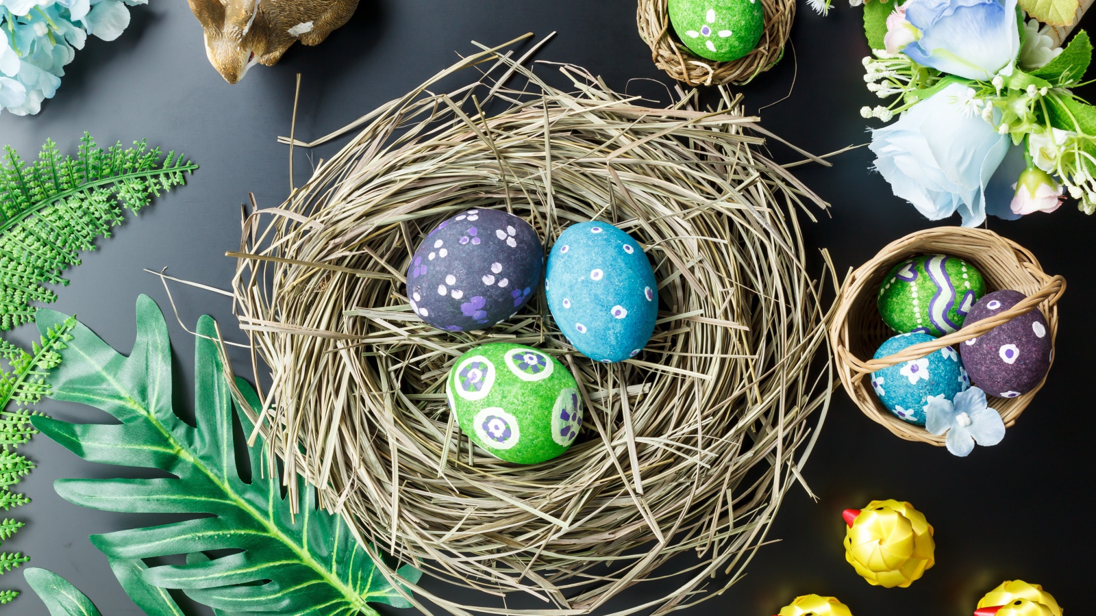 Яркие пасхальные яйца на столе в гнезде