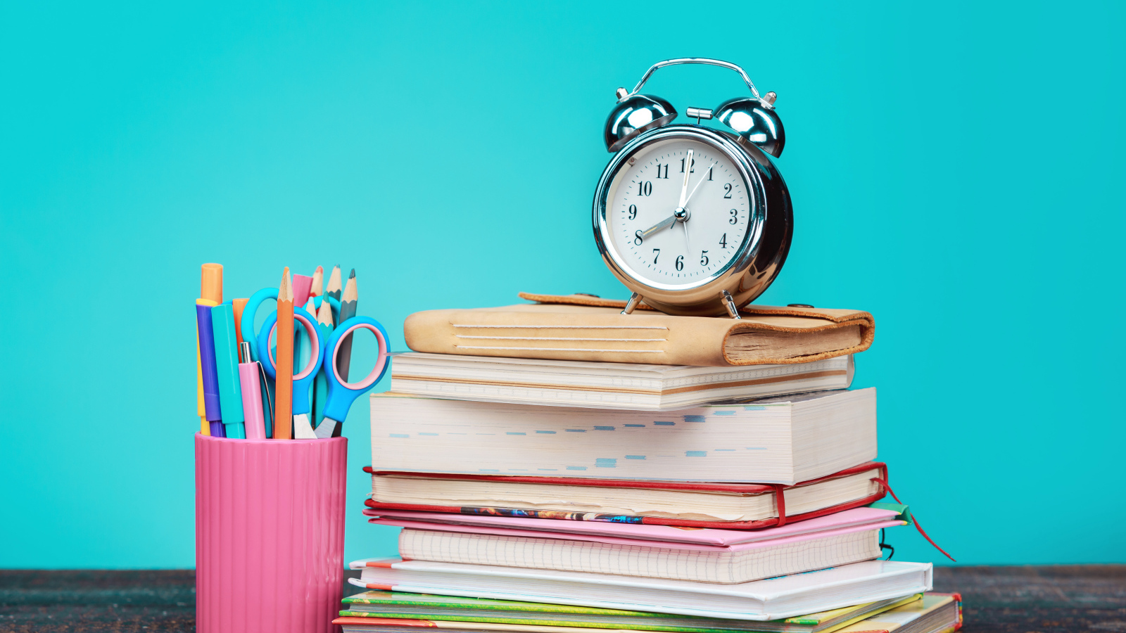 Будильник, книги и канцелярские предметы для школы
