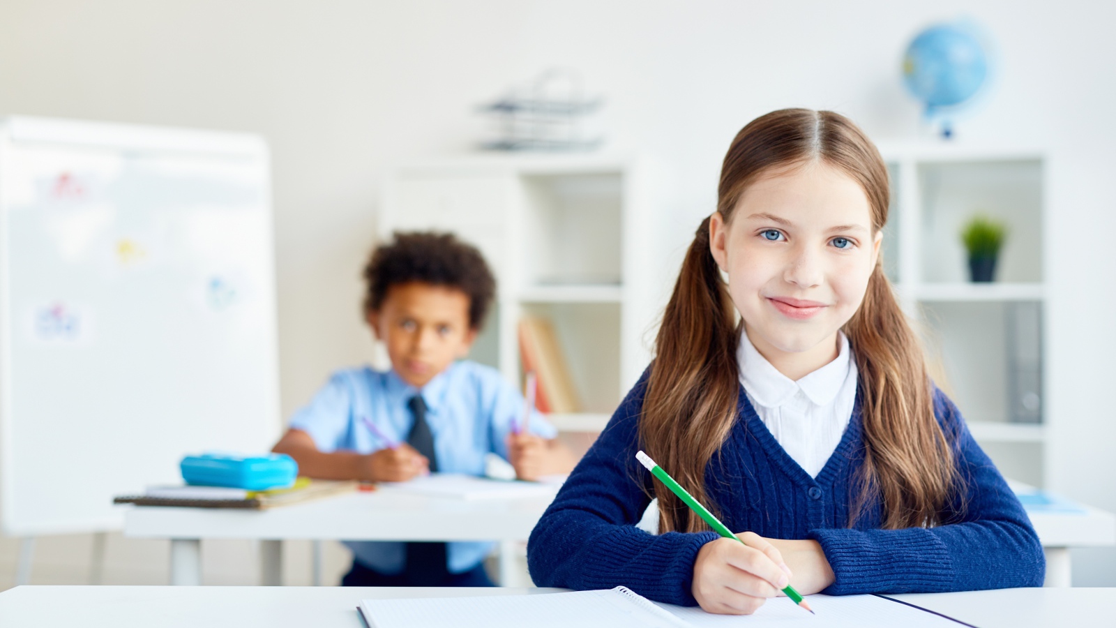 Девочка школьница сидит за партой в школе 