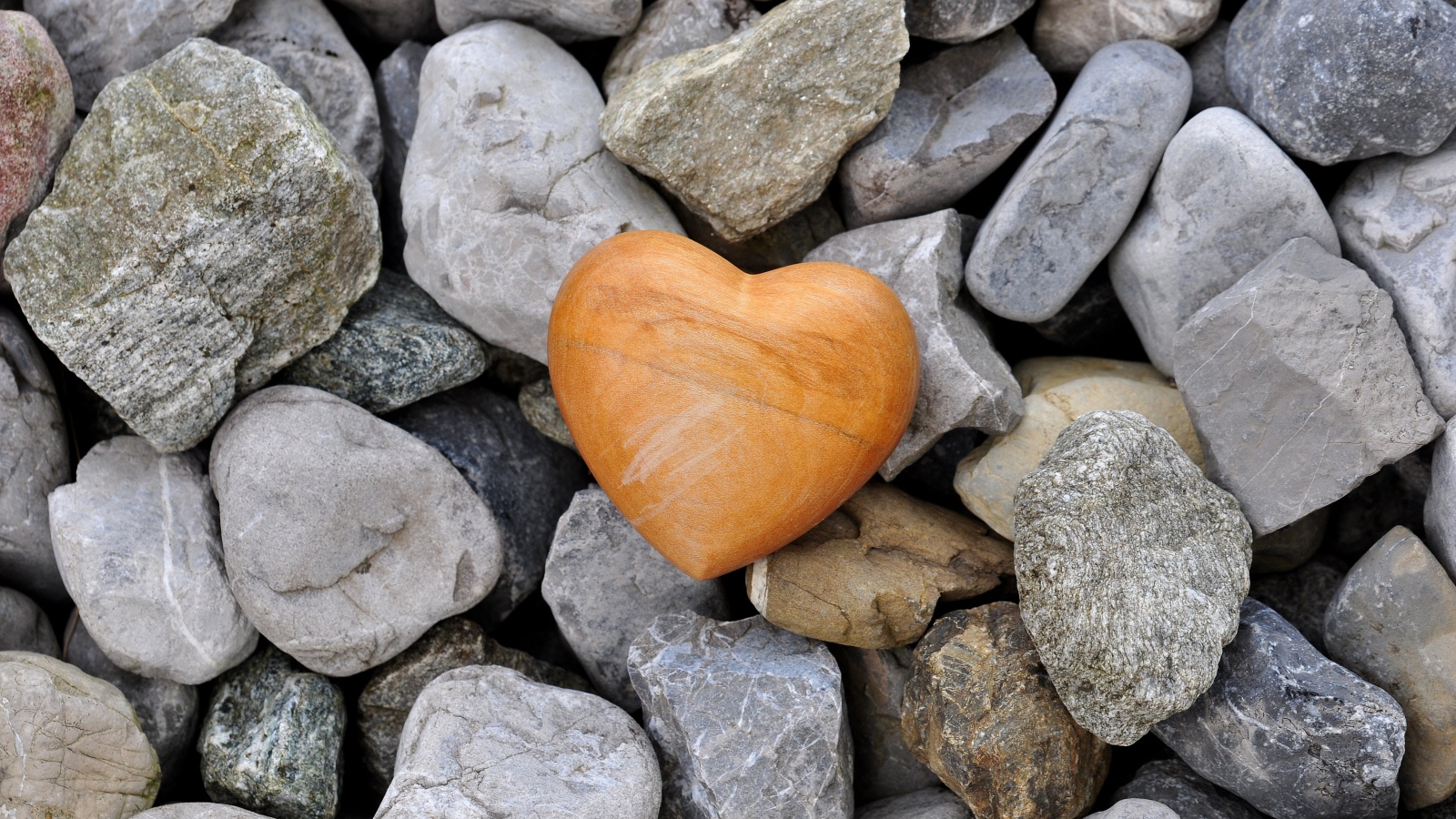 Каменное сердце лежит на камнях 
