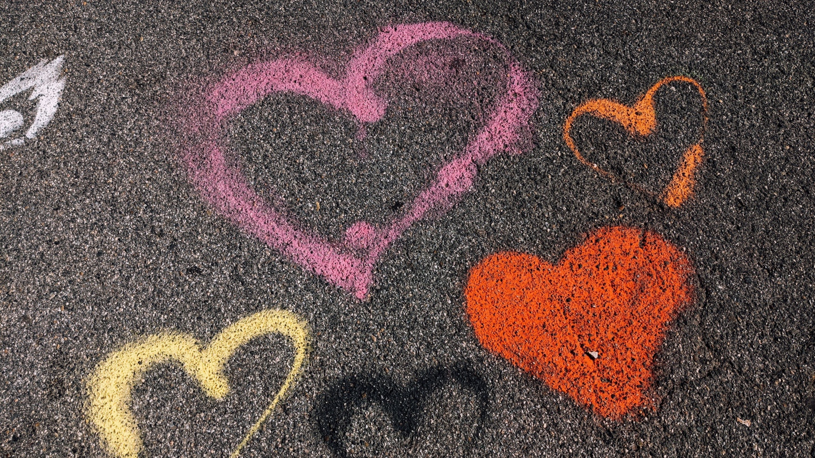 Сердечки разноцветным мелом на асфальте
