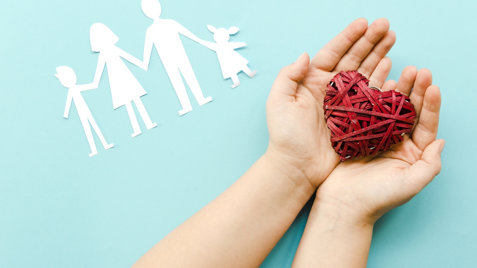 Плетеное сердце в руках на голубом фоне