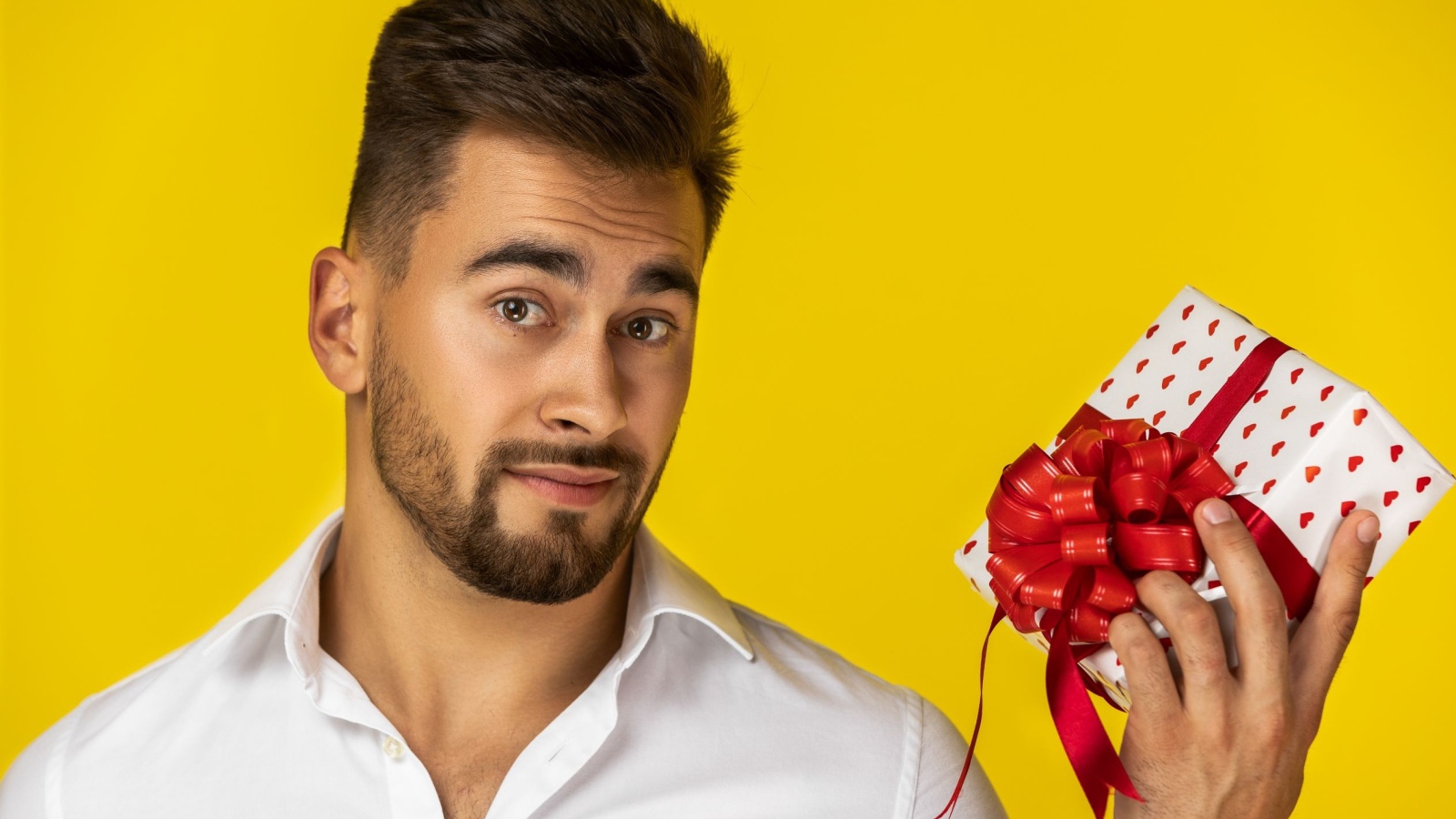 Мужчина с подарком на желтом фоне 