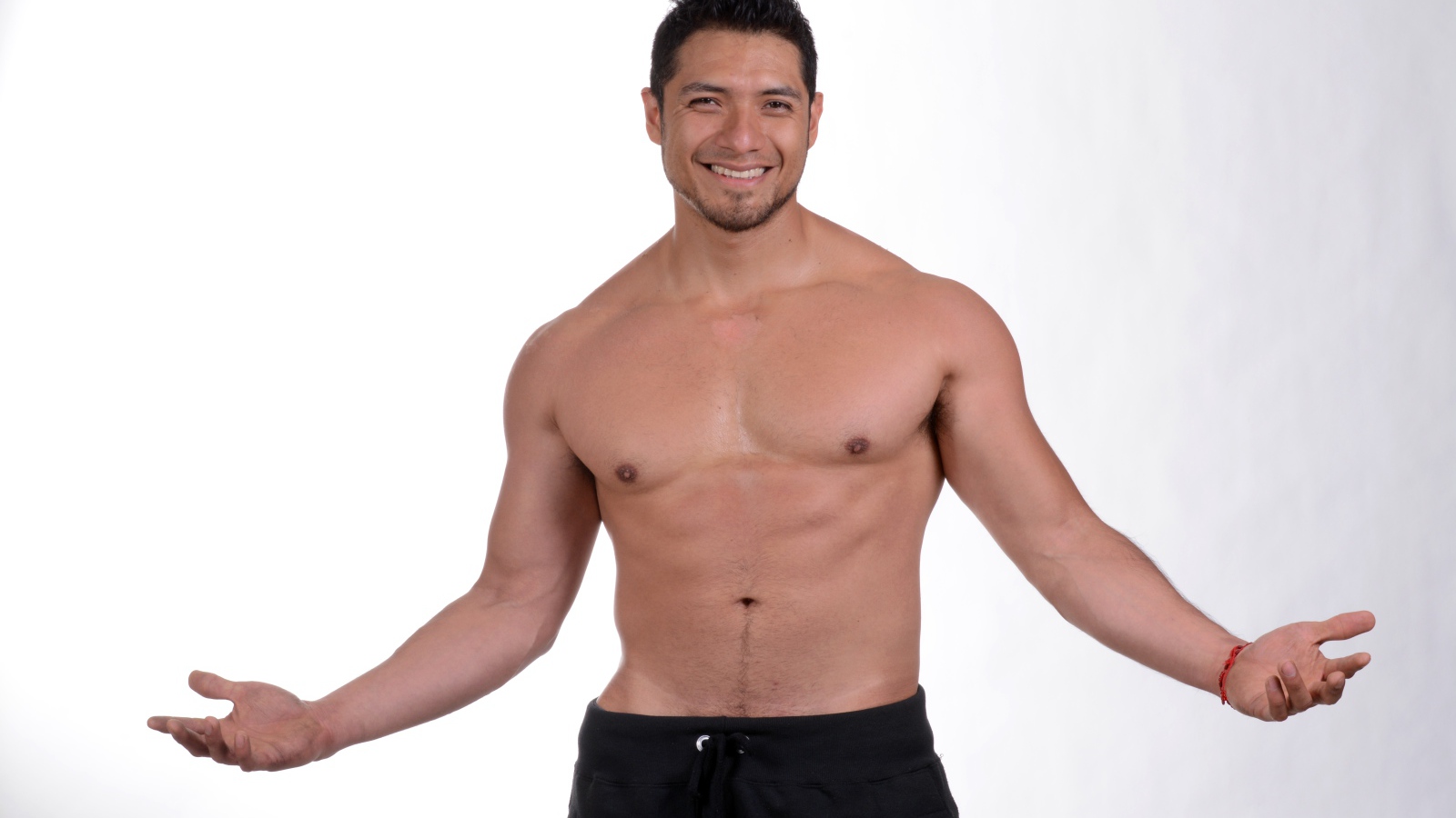 Улыбающийся накаченный мужчина на сером фоне