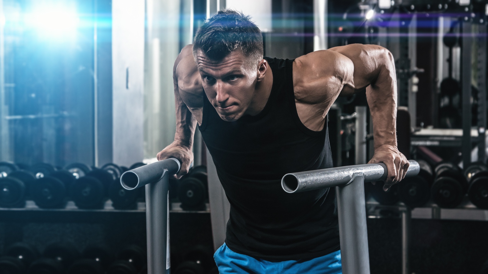 Сильный накаченный мужчина занимается в спортзале 