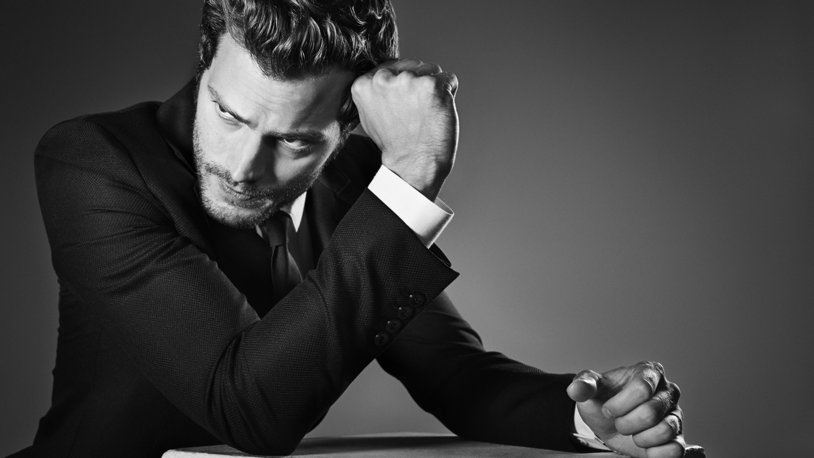 Британский актер Джейми Дорнан на сером фоне